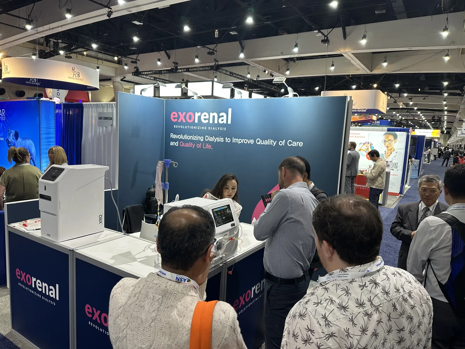 A crowd of clinicians around XKIDNEY at the Exorenal booth