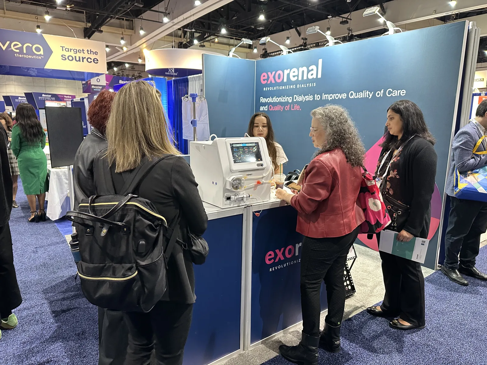Visitors talking with our team in front of the booth
