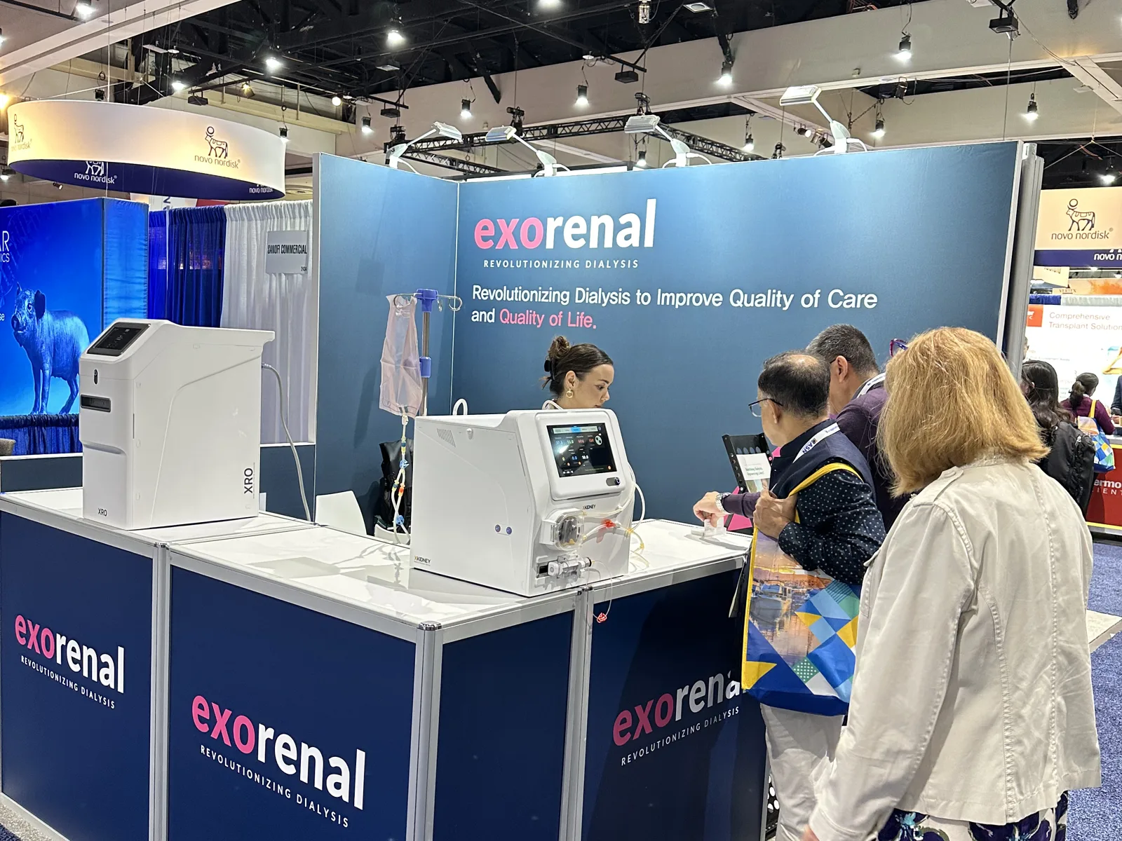 Visitors at the booth table with XKIDNEY and XRO