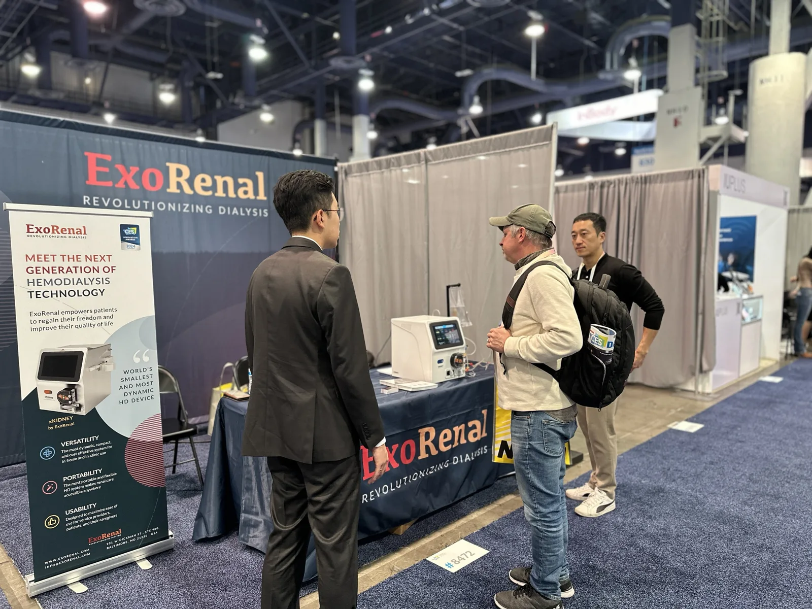 Our team explaining XKIDNEY to a visitor at the Digital Health hall booth