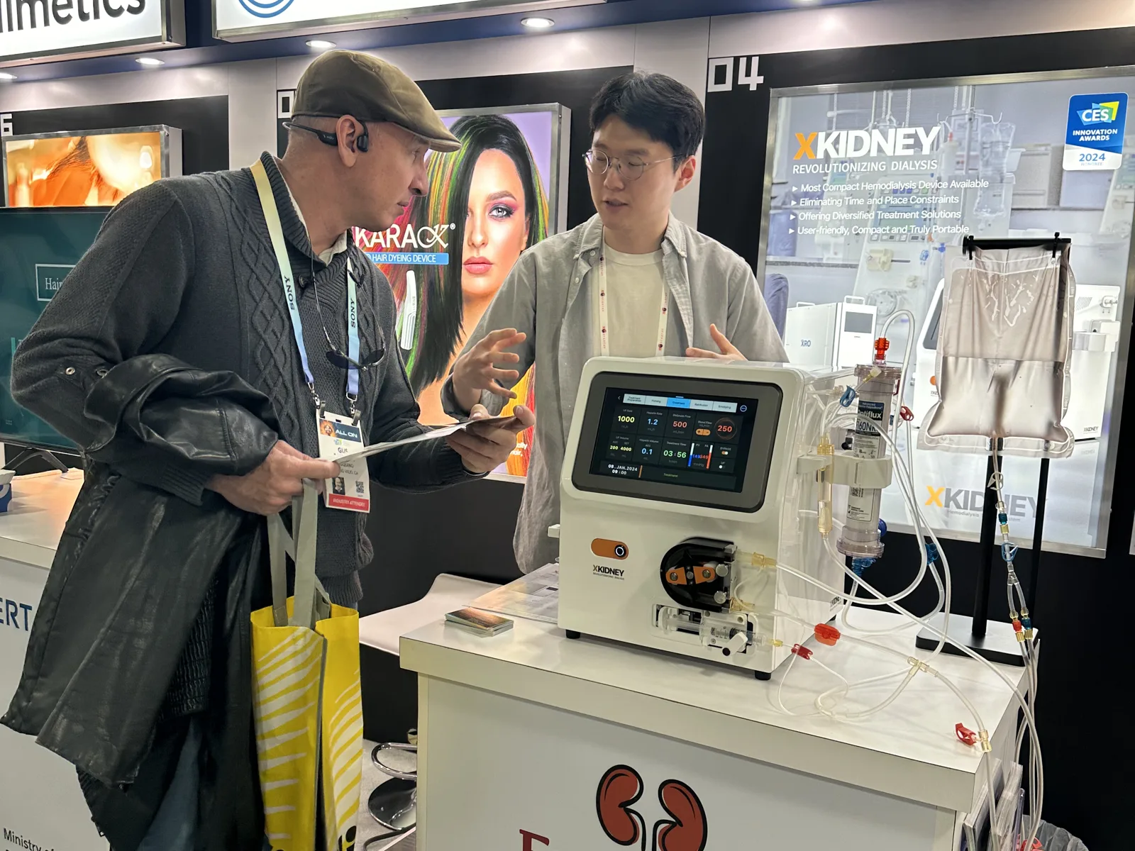 Explaining XKIDNEY to a visitor at the Korea Startup pavilion