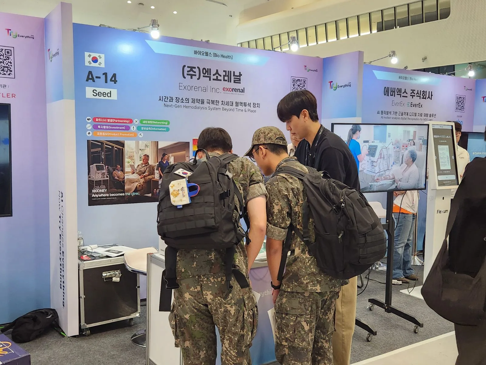 Our team talking with visitors in front of the booth display